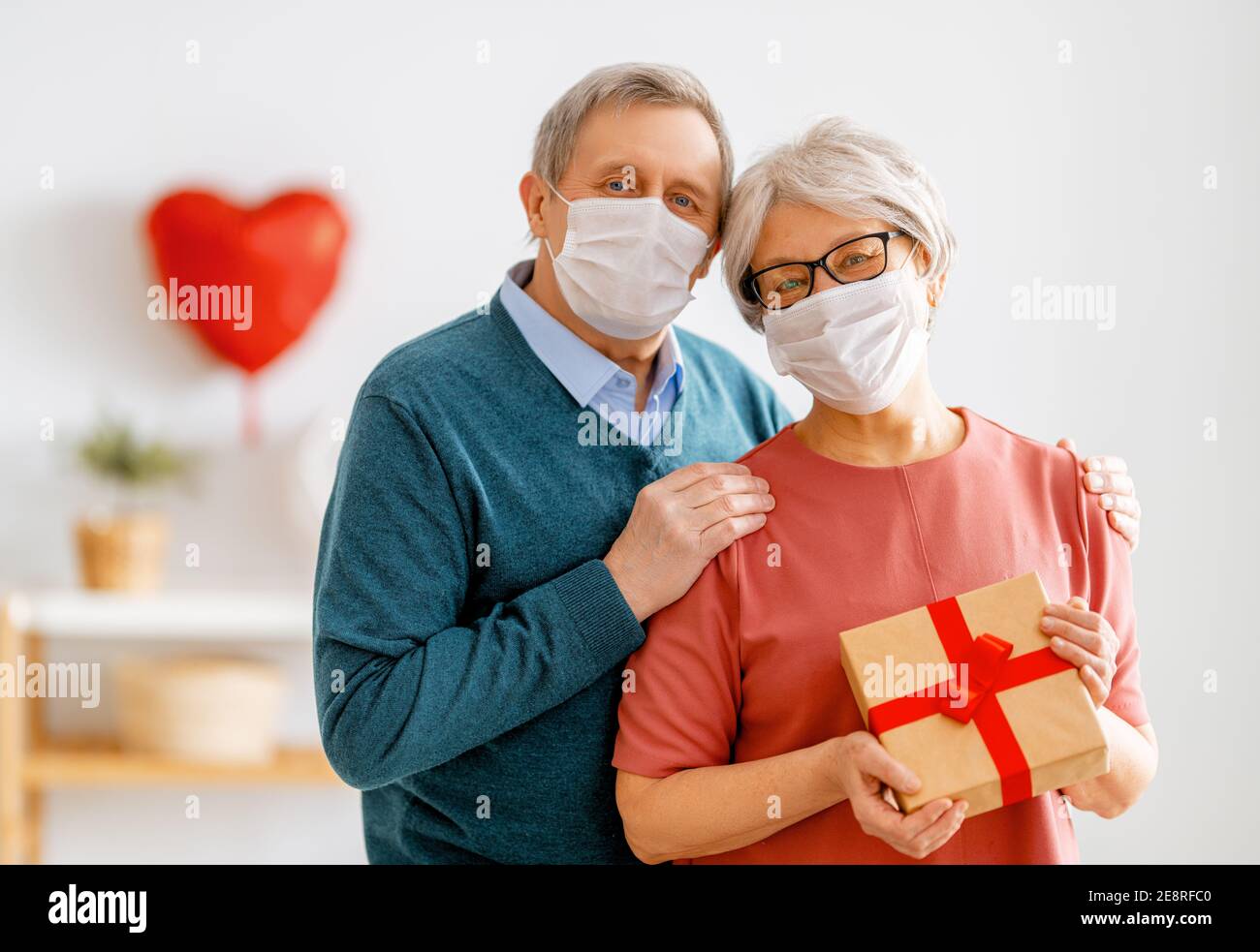 Couple Elderly Female Friends Wearing Face Mask Giving Christmas Present  Stock Photo by ©BasilicoStudioStock 430210076