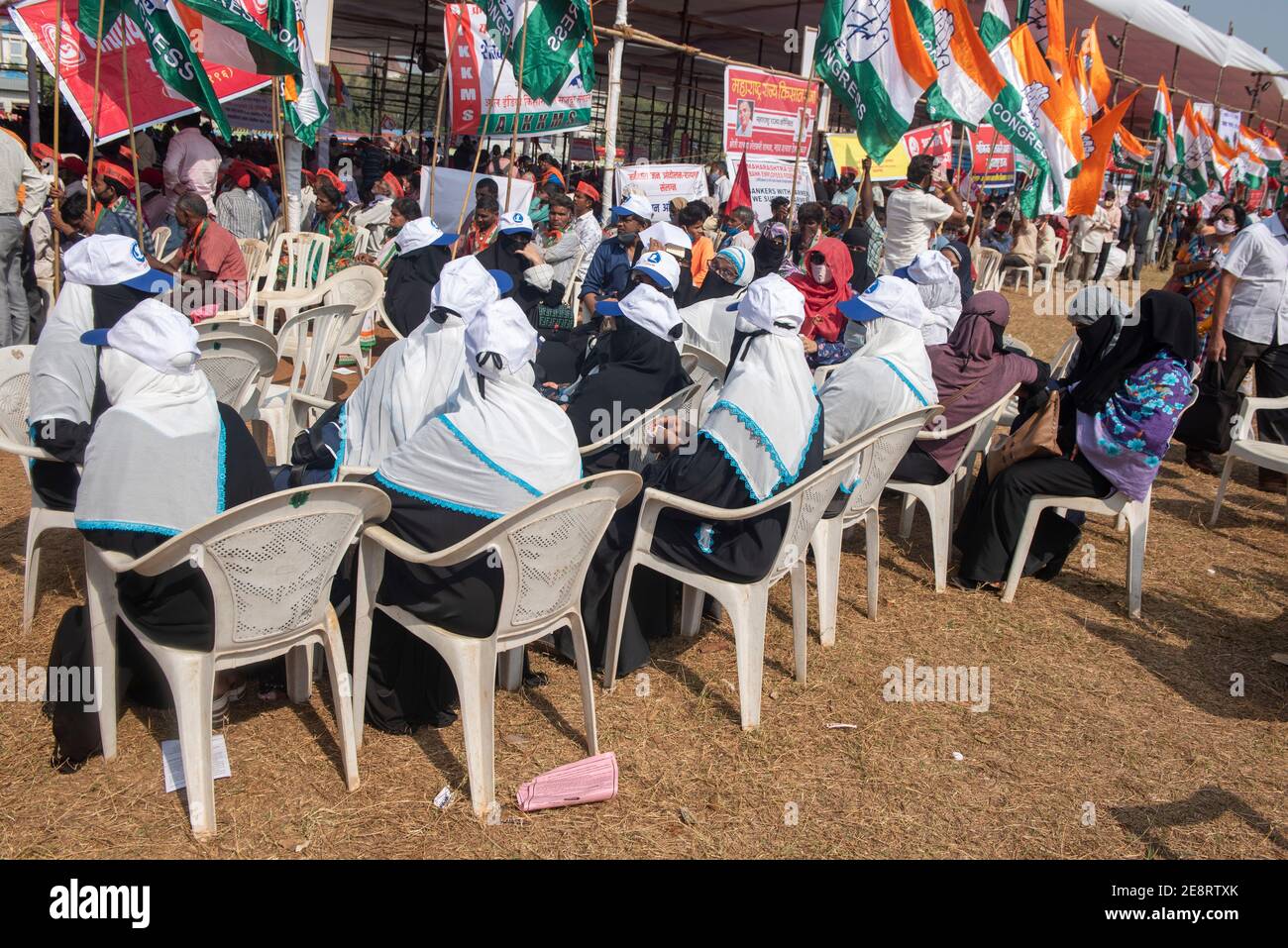 Mumbai , India - 25 January 2021, Muslim woman activists protesters in a black burqa hold up indian flag and signs sitting   near pandal in a rally at Stock Photo
