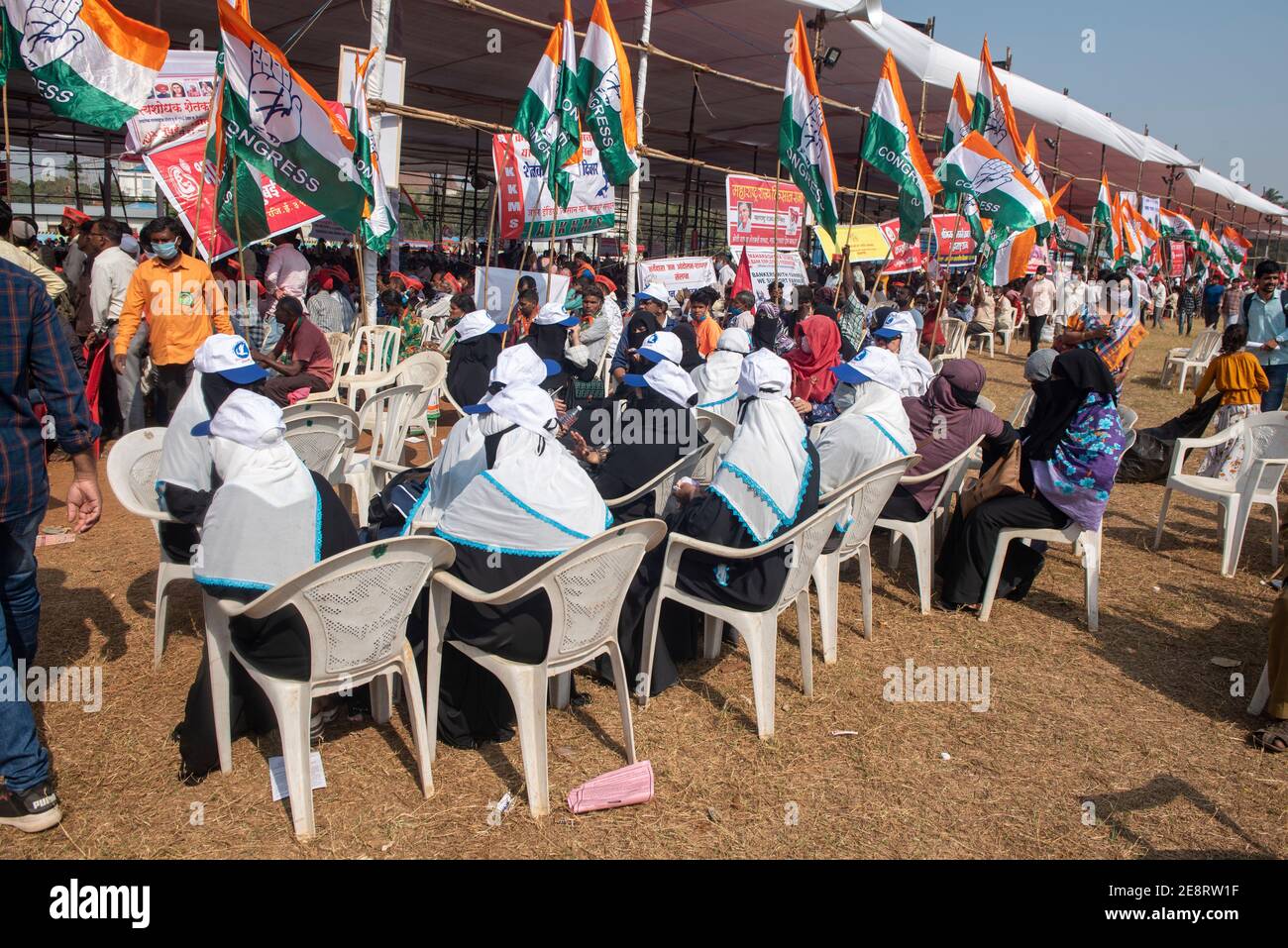 Mumbai , India - 25 January 2021, Muslim woman activists protesters in a black burqa hold up indian flag and signs sitting   near pandal in a rally at Stock Photo