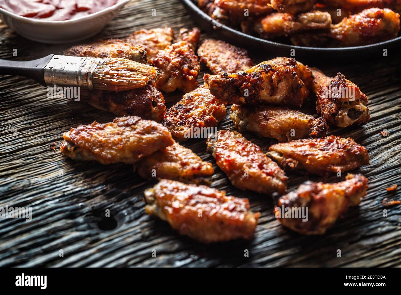 Chicken wings barbeque in a cast iron baking dish with BBQ sauce Stock Photo