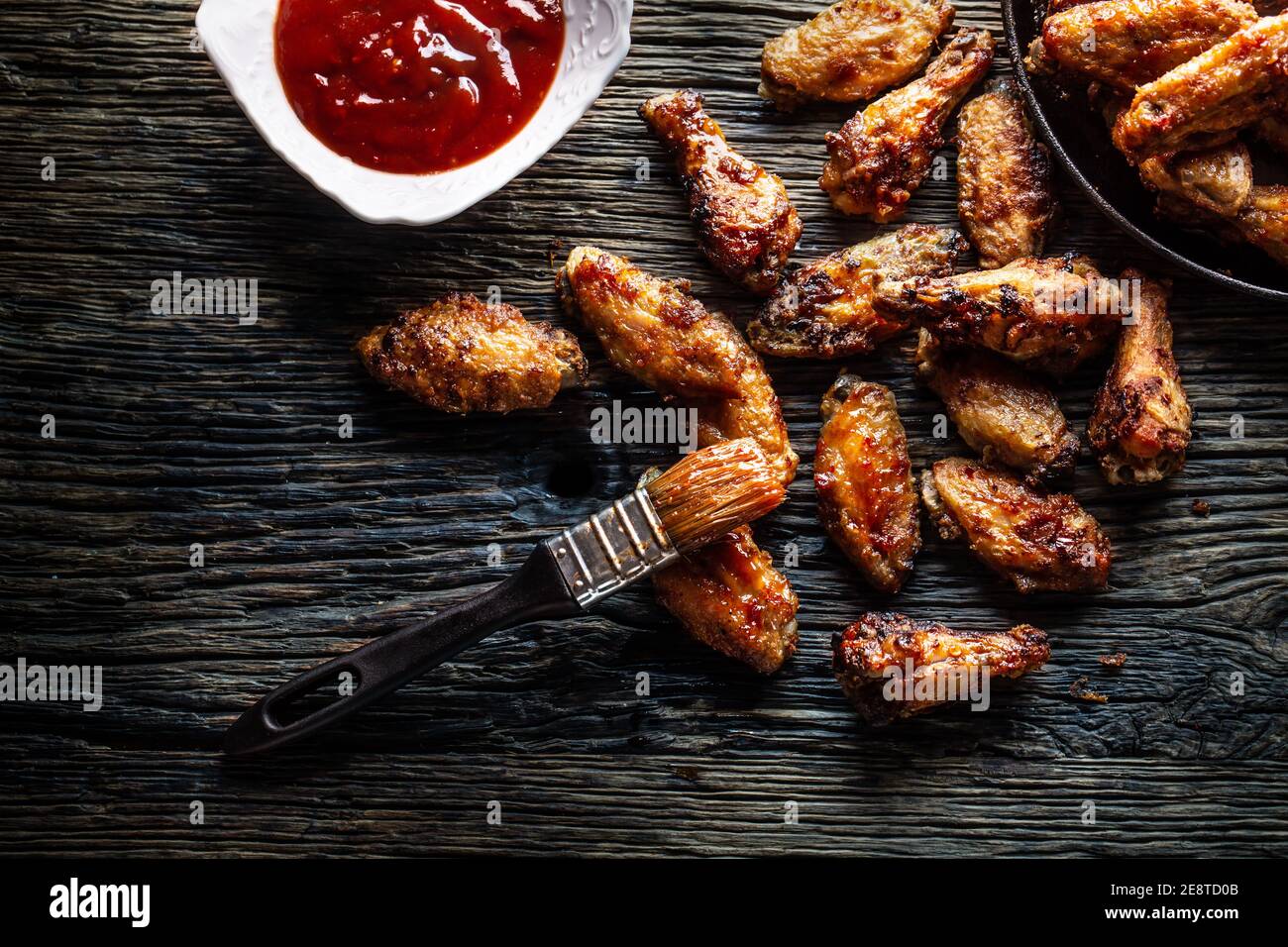 Chicken wings barbeque in a cast iron baking dish with BBQ - Top of view Stock Photo