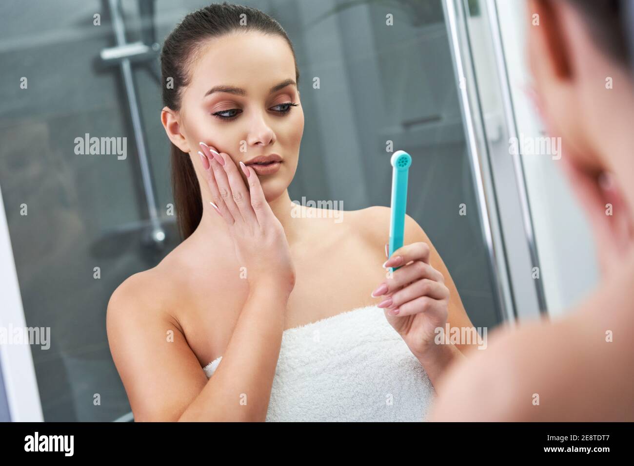 Woman looking on reflection in the mirror after shower Stock Photo Alamy