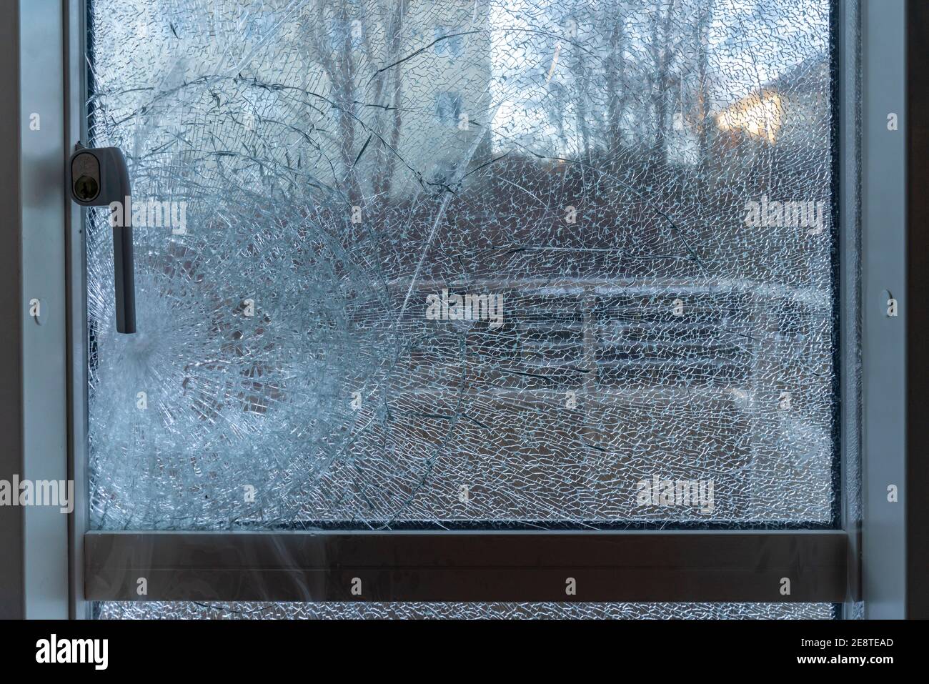 Broken balcony glass door window with shattered glass, burglar entering