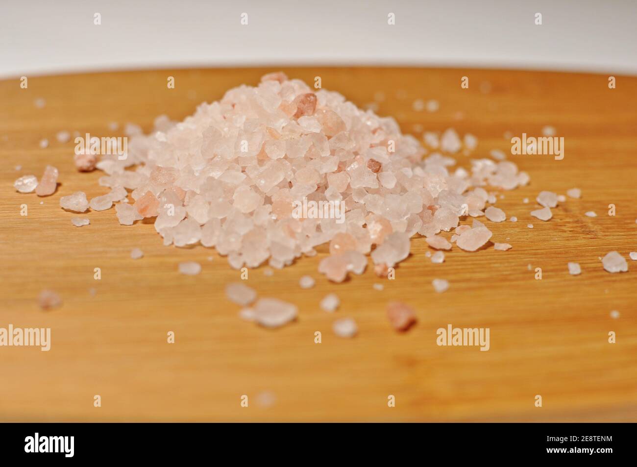 Concept of raw organic Himalayan pink salt heap on wooden plate Stock Photo
