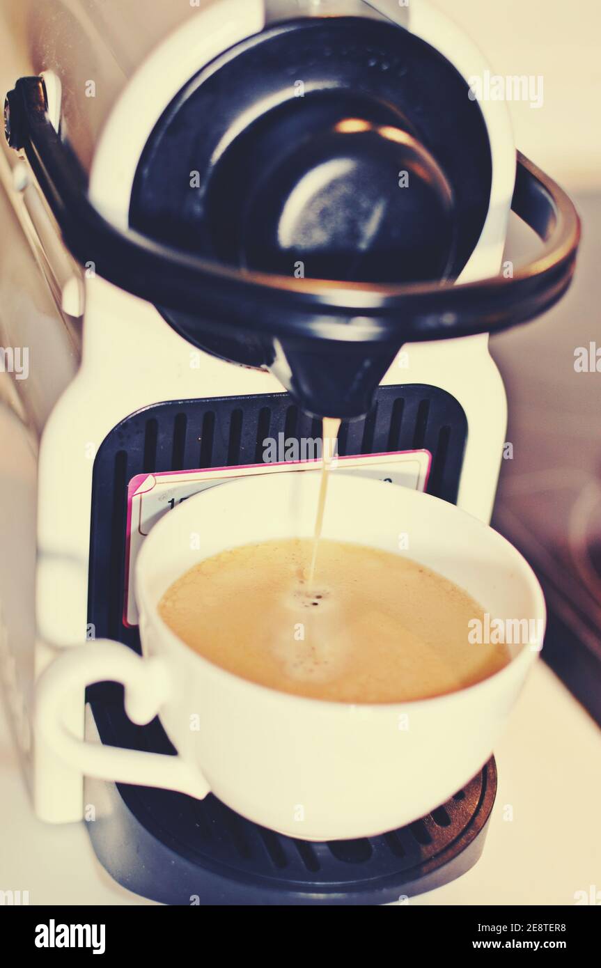 Making a cup of coffee at espresso machine. Front view, vertical Stock Photo