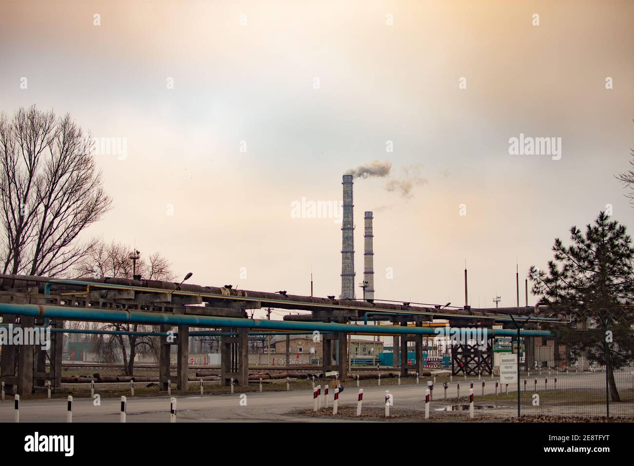 Industrial zone with a large two pipes smoke is poured from the factory pipe. Pollution of the environment. Stock Photo