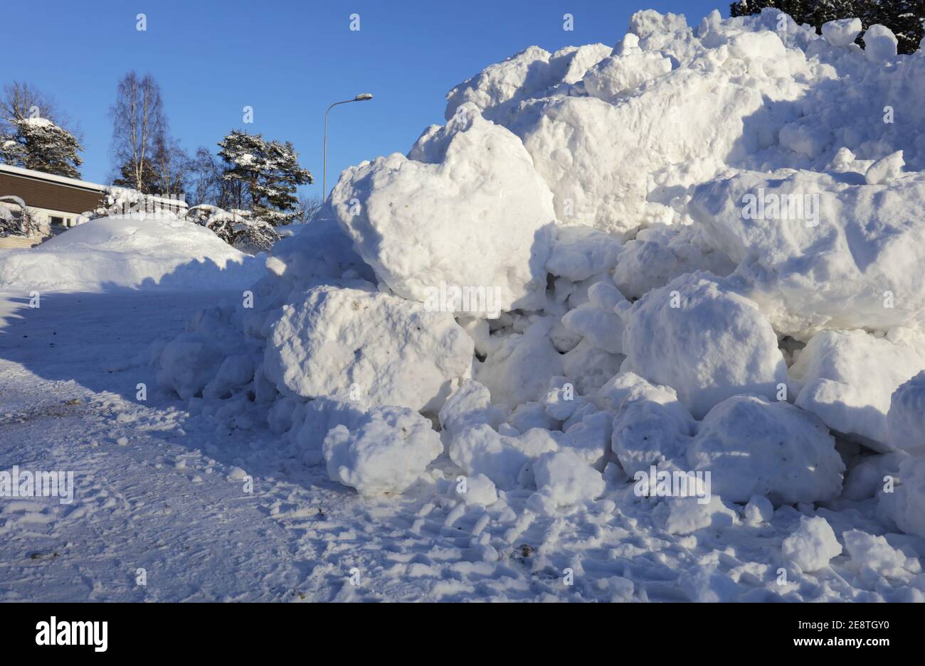 Lot´s of snow along a street, sunshine today. Heavy snowfall a few days before. Stock Photo