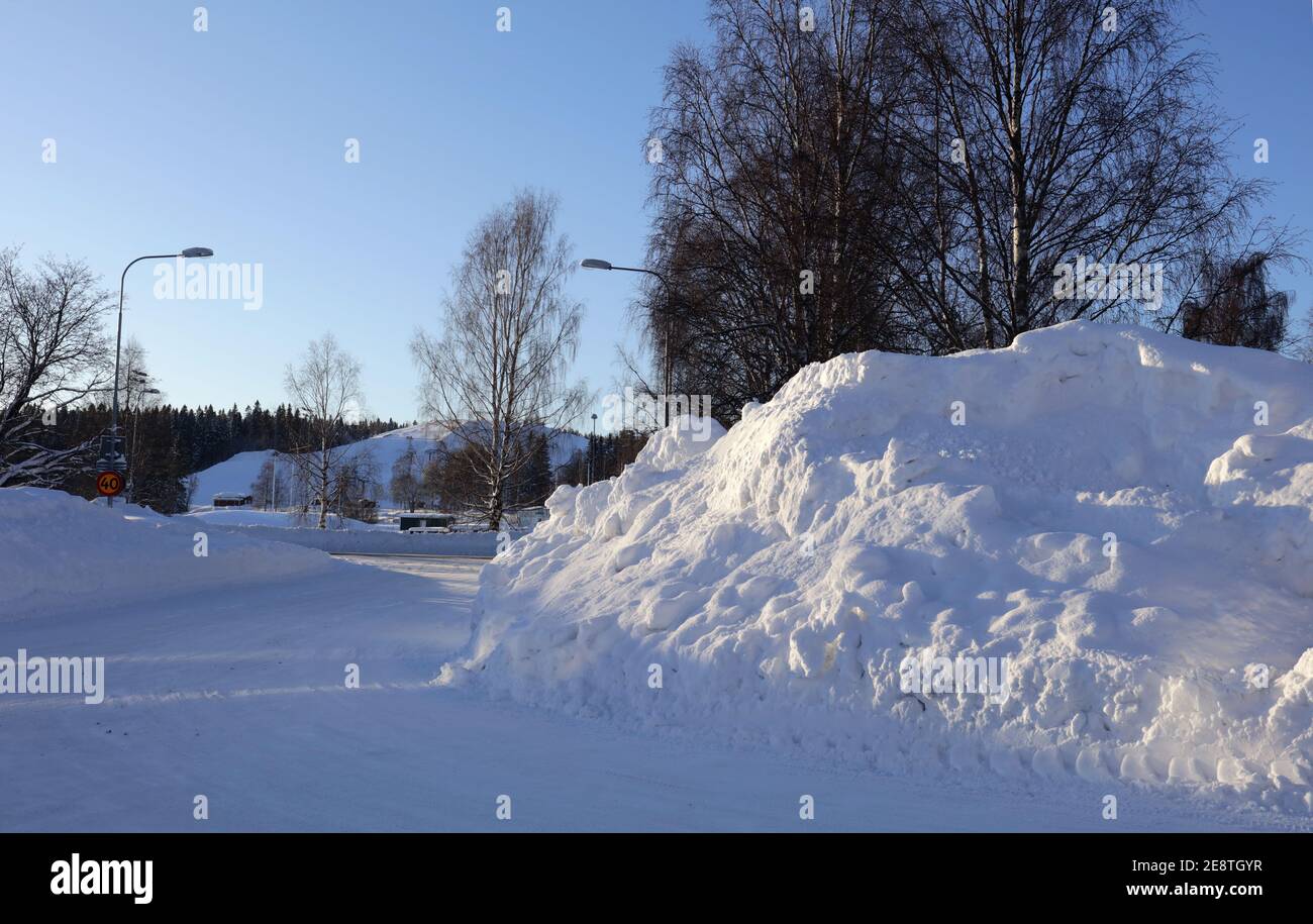 Lot´s of snow along a street, sunshine today. Heavy snowfall a few days before. Stock Photo