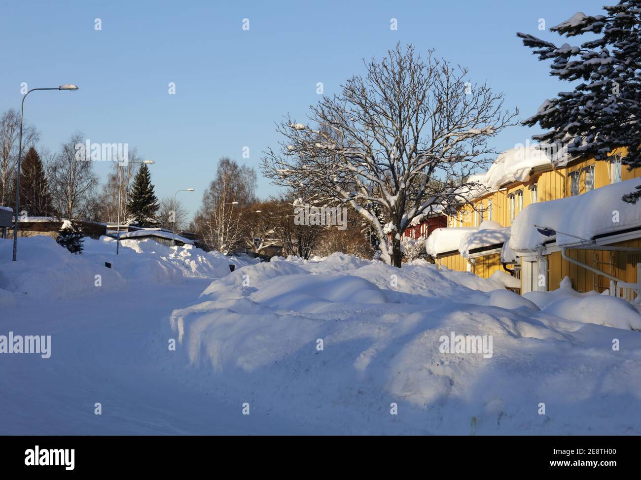 Lot´s of snow along a street, sunshine today. Heavy snowfall a few days before. Stock Photo