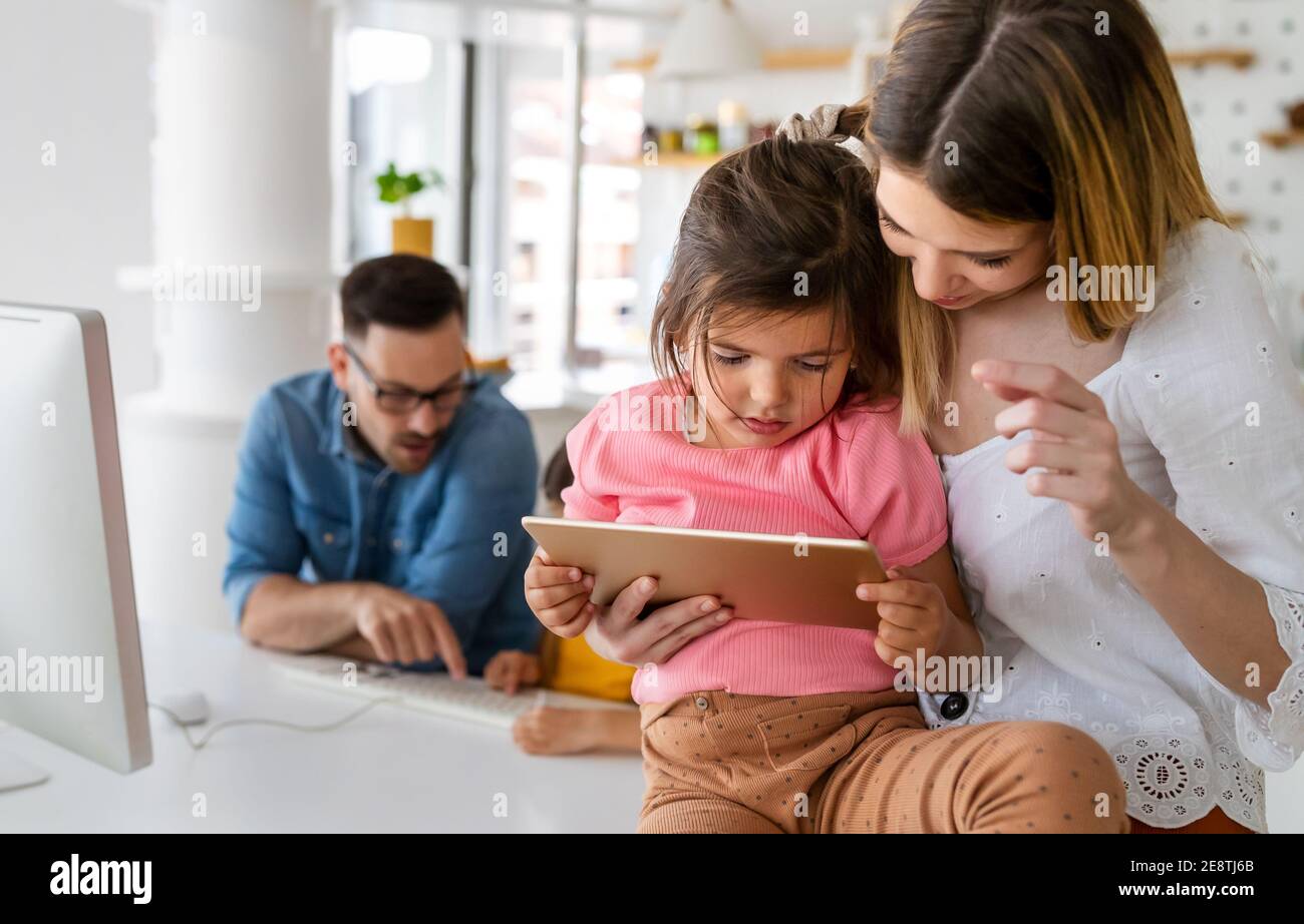 Parents helping to children studying online at home. Lockdown and online school, technology concept. Stock Photo