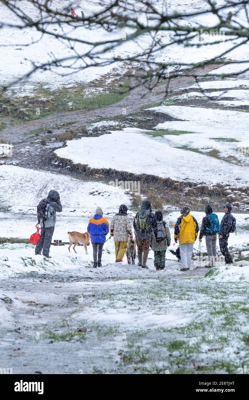 A group of walkers preparing to walk up Rough Tor in the snow on Bodmin Moor in Cornwall. Stock Photo