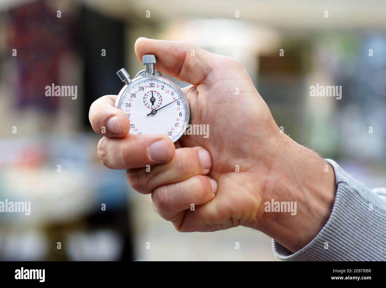 Trainer holds stopwatch in his hand and presses start and stop button
