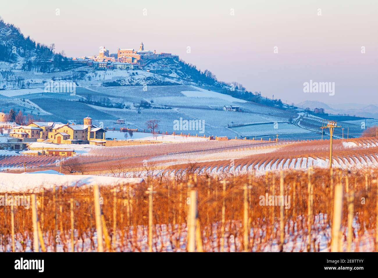 Italy Piedmont: wine yards unique landscape winter, La Morra village perched on hill top, sunset dramatic sky background, italian grapes heritage pano Stock Photo