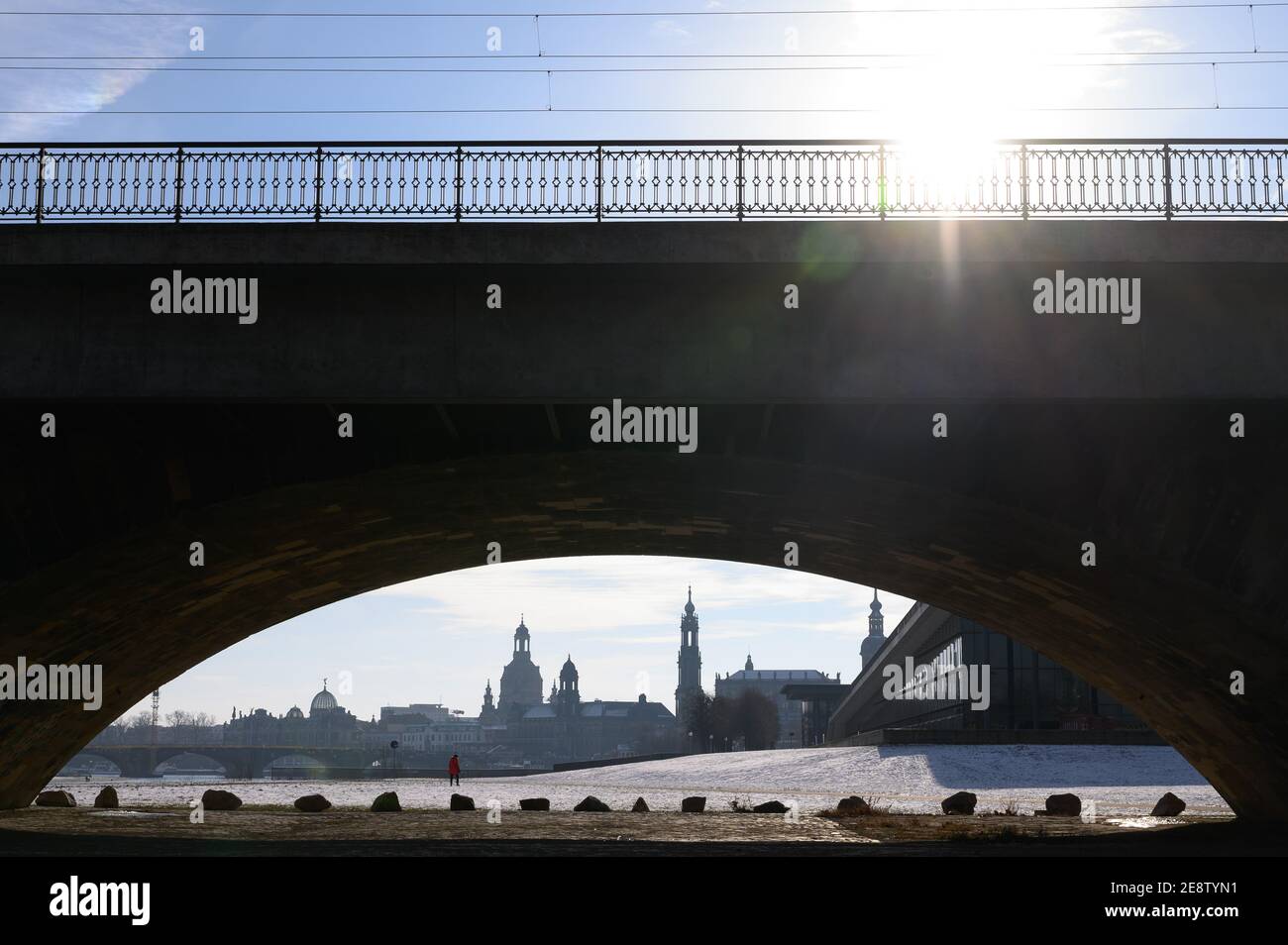 01 February 2021, Saxony, Dresden: Passers-by walk through the snow on the banks of the Elbe behind the Marienbrücke against the backdrop of the old town. Photo: Sebastian Kahnert/dpa-Zentralbild/dpa Stock Photo