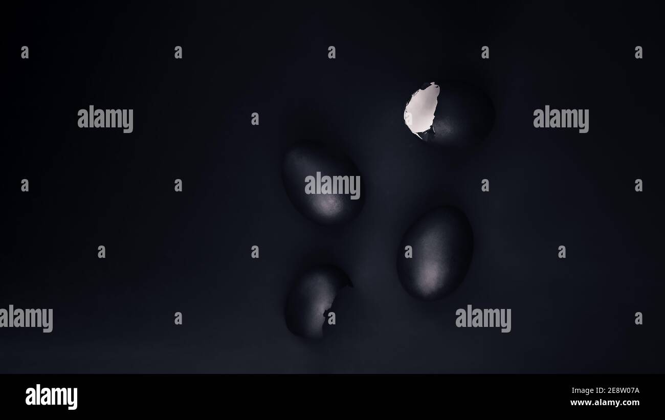 Some black painted Easter eggs on black background, flat lay with copy space Stock Photo