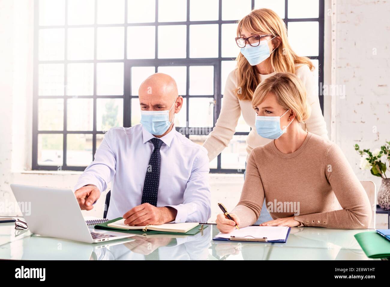 Group of business people wearing face masks while working together in ...
