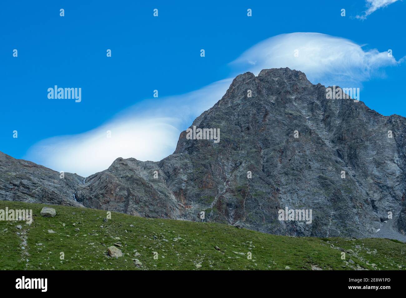 Typical clouds surrounding a peak during föhn, a stormy wind in Switzerland Stock Photo