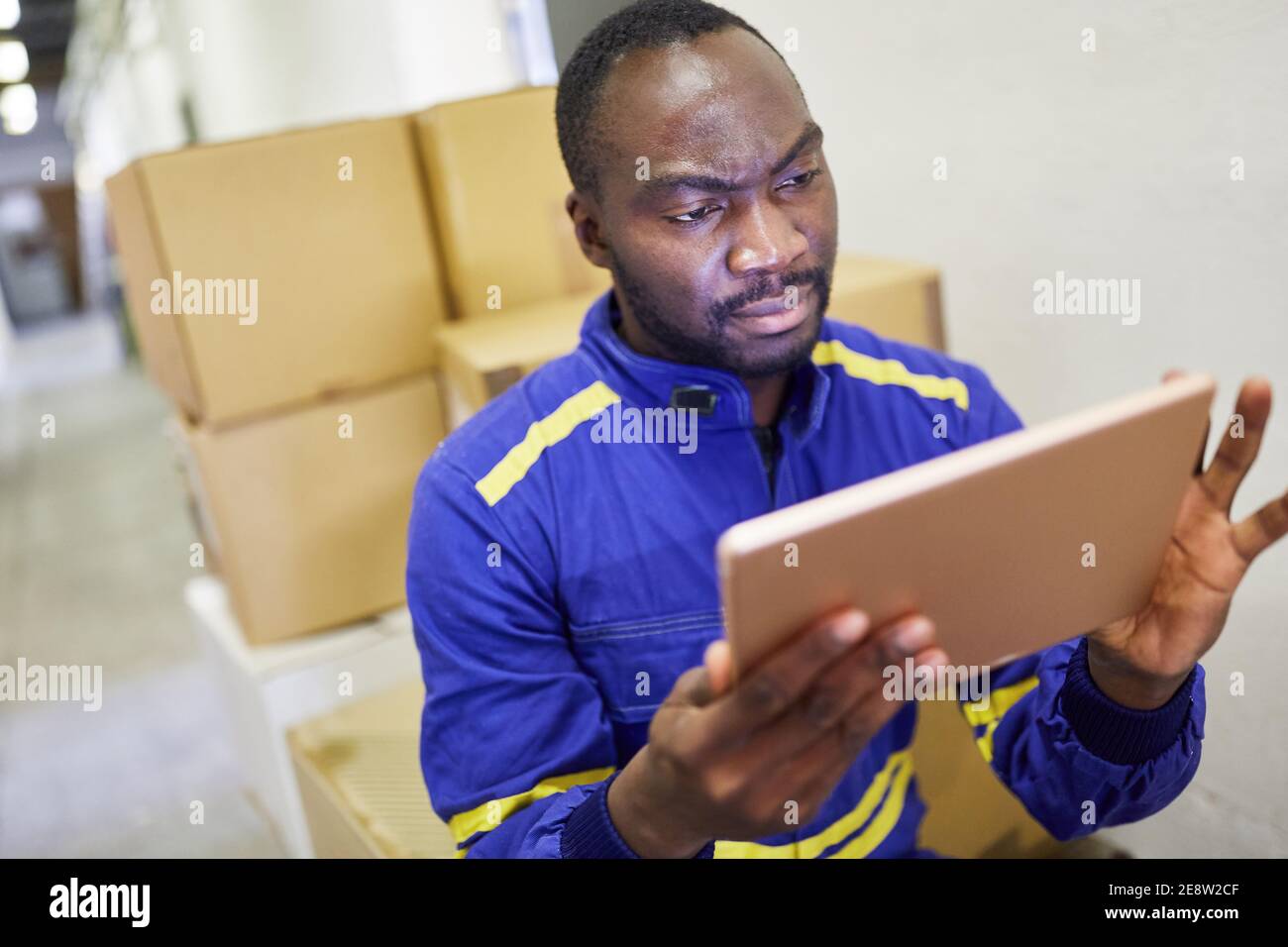 African warehouse worker using tablet computer before shipping in online trade Stock Photo