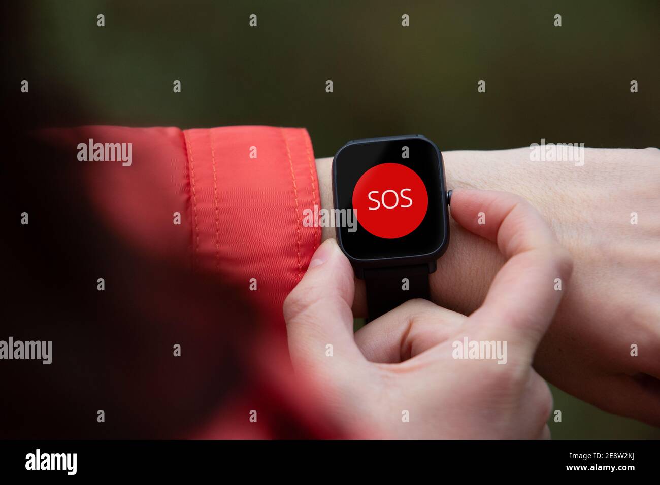 hands of a woman calling for help from the emergency service through the smart watch Stock Photo