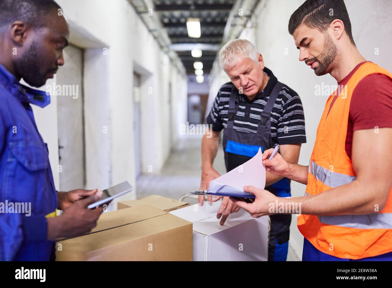 Warehouse workers team and warehouse clerk checking a delivery of goods