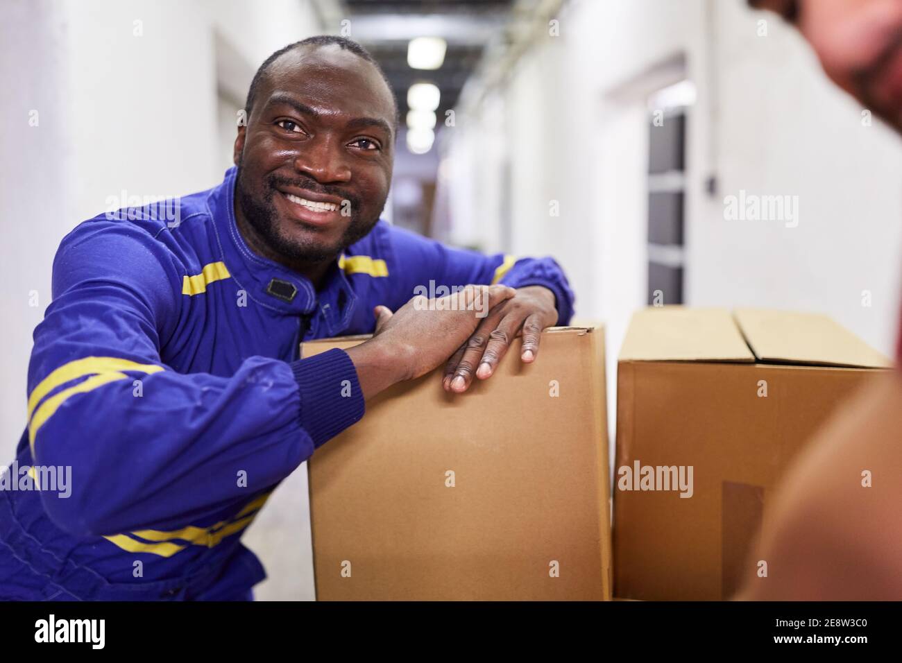 African worker as a mini jobber or temporary worker with parcels at a shipping company Stock Photo