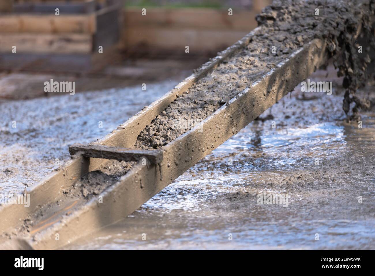 Self-made chute for concreting works. Concrete pours down a wooden chute Stock Photo