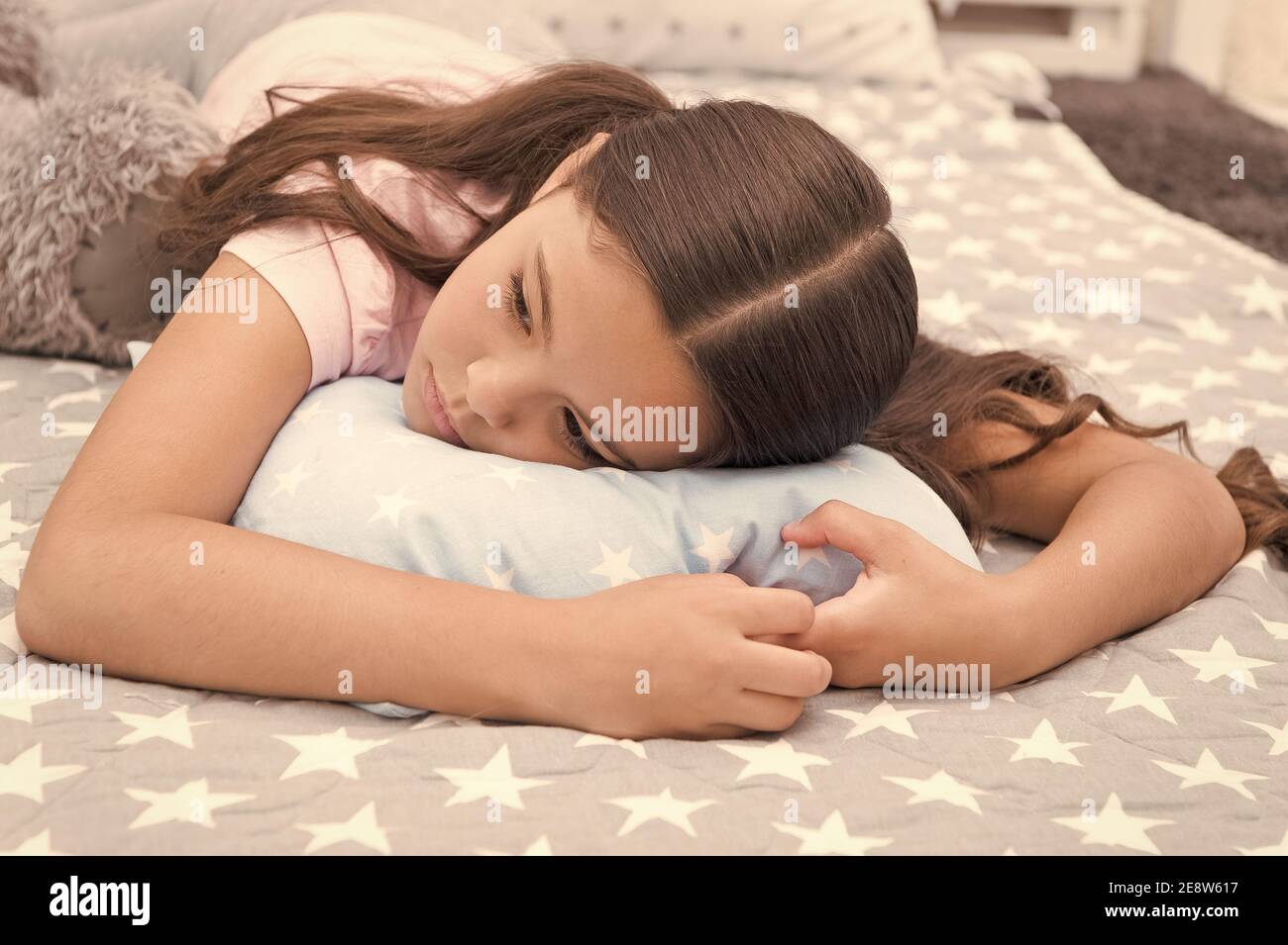Sleepy beauty. Sleepy baby. Small girl relax in bed. Little child with sleepy look. Early morning or late evening. Bedtime routine. Nap time. She feels sleepy. Stock Photo