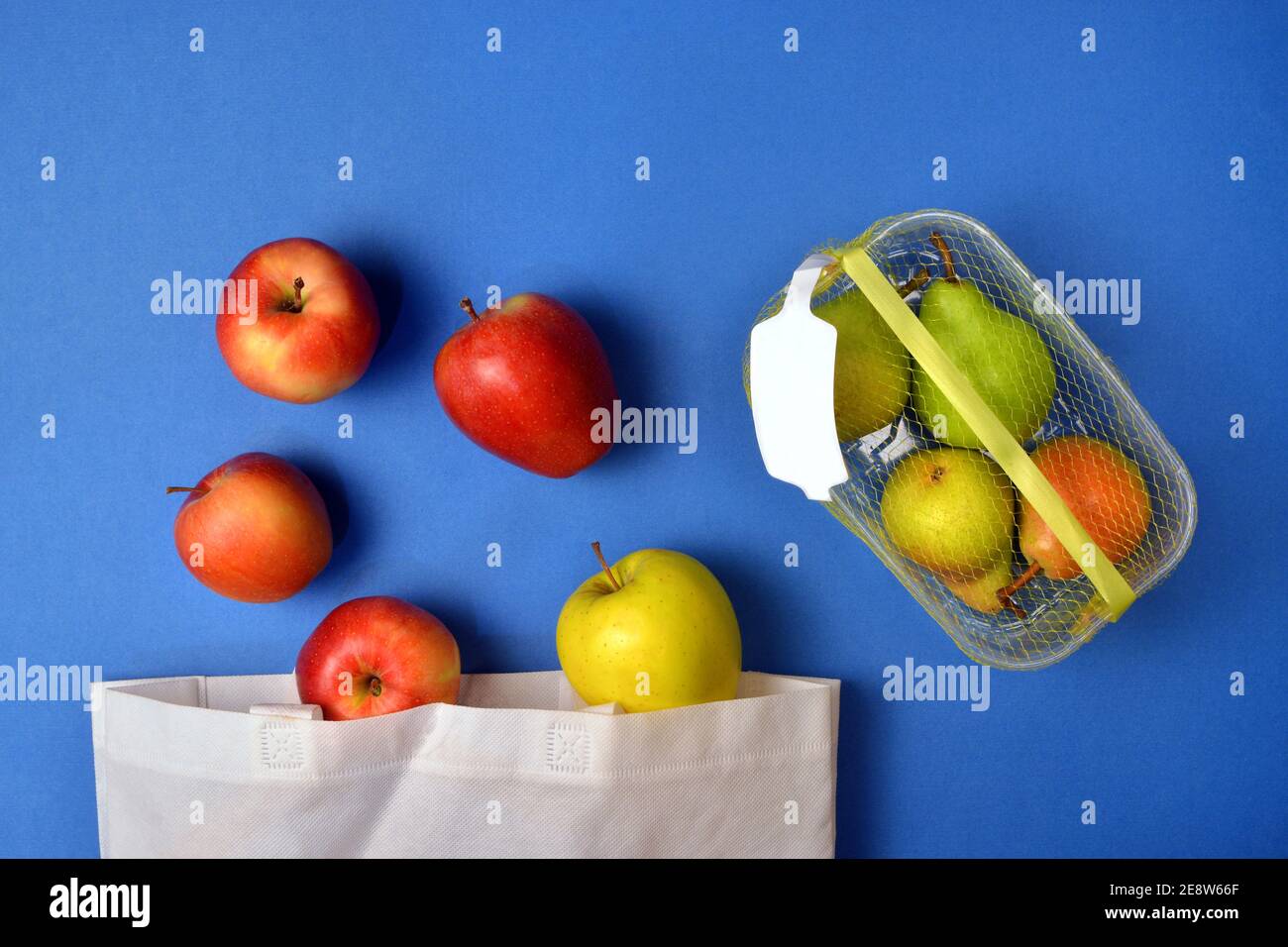 Detail of fruit purchased in plastic packaging and in reusable fabric bags Stock Photo