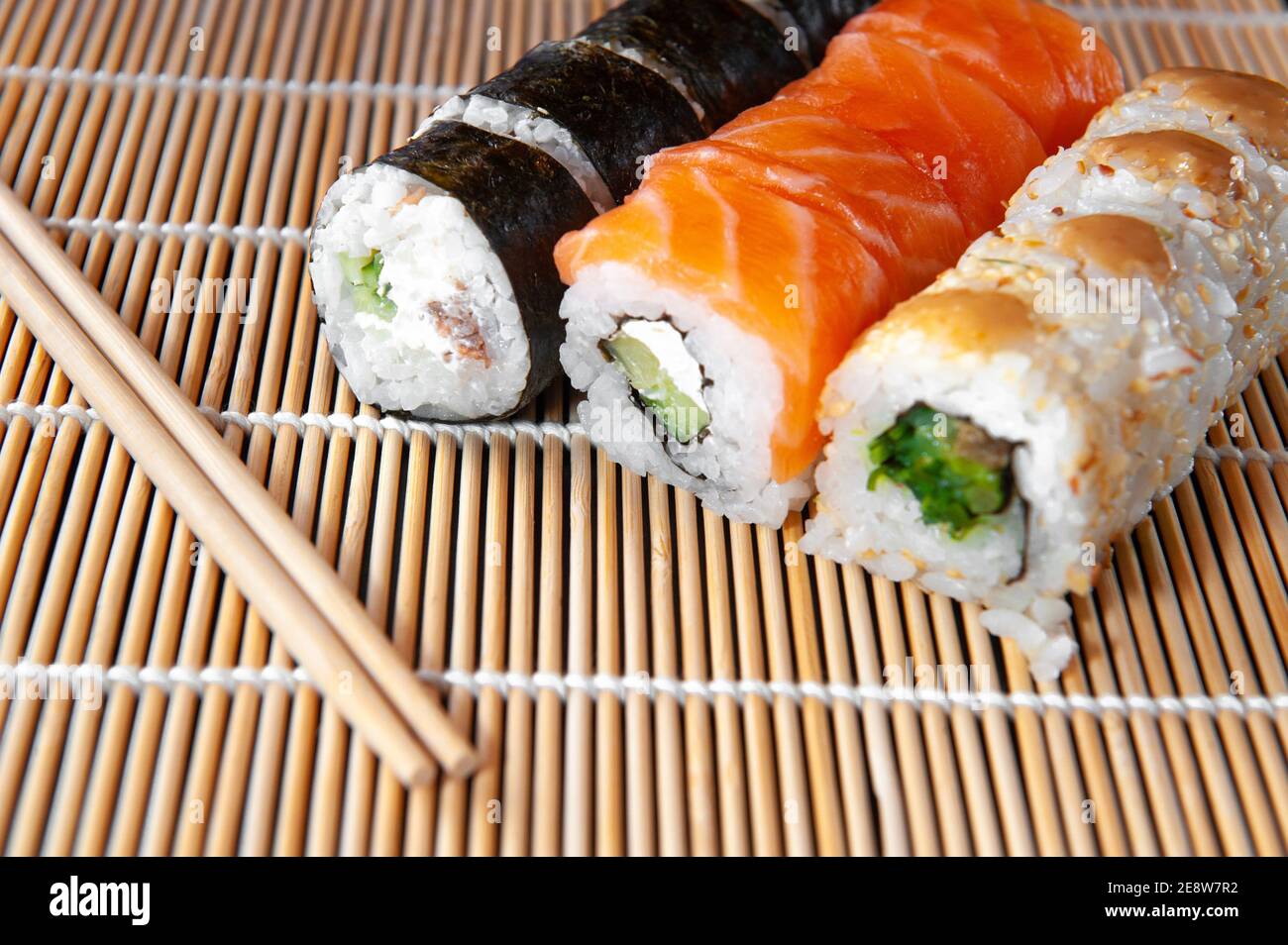 https://c8.alamy.com/comp/2E8W7R2/group-of-fresh-rolled-sushi-on-bamboo-sushi-mat-2E8W7R2.jpg
