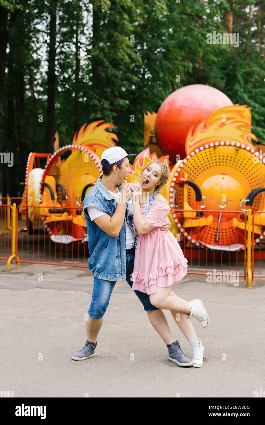 Happy young couple in love having fun in an amusement park and dancing ...