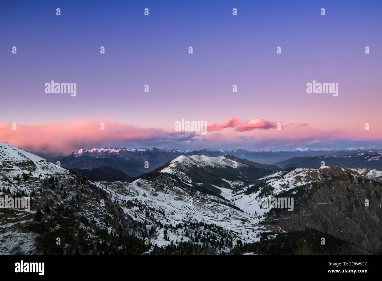 Scenic snowy mountain valley in the purple sky backgr Stock Photo