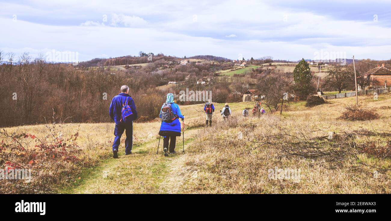 Hiking, Travel, Healthy Lifestyle, Group of active people walking on the rural landscape Stock Photo
