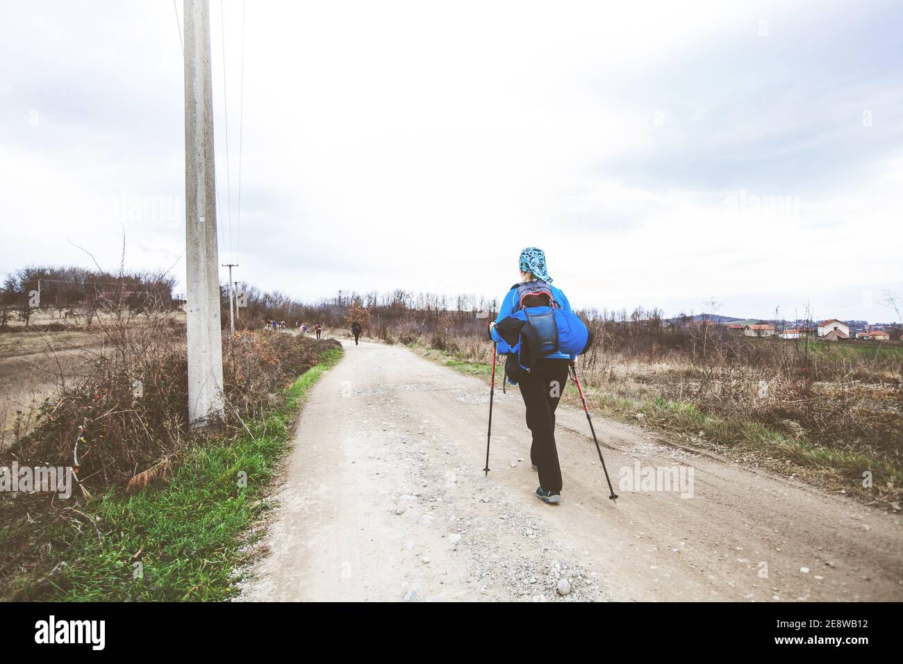 Hiking, Travel, Healthy Lifestyle. Active people with backpack walking on a rural landscape in autumn day. Stock Photo