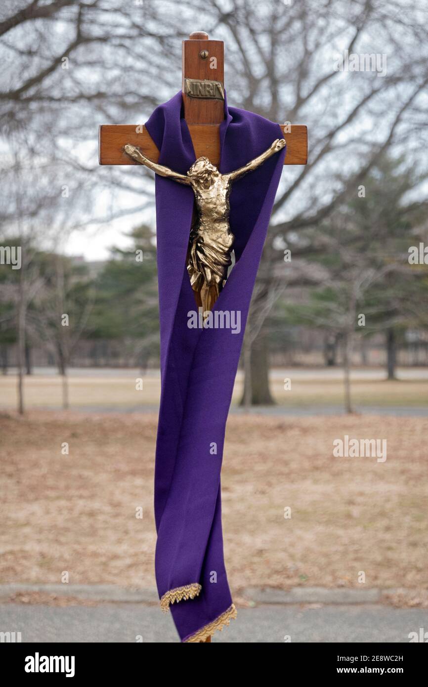 A large crucifix cross with Jesus draped in purple, the color of lent