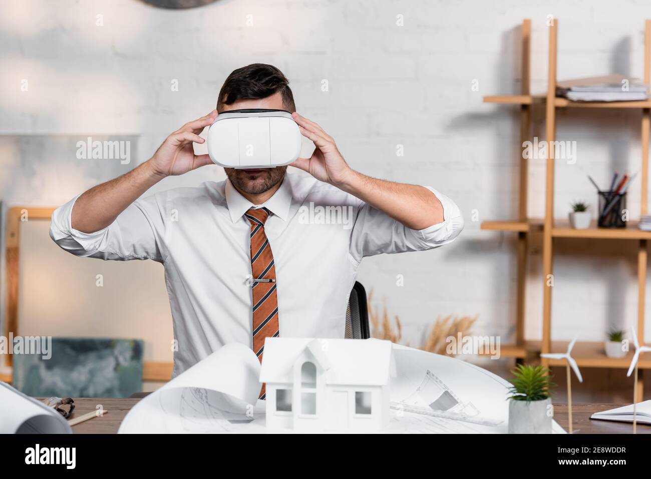 architect touching vr headset at workplace near blueprint and house model Stock Photo