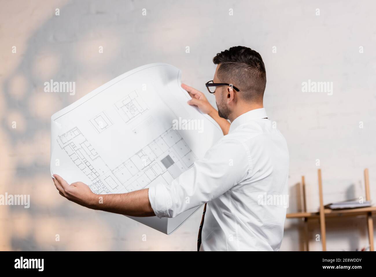 architect holding blueprint in architectural agency Stock Photo Alamy