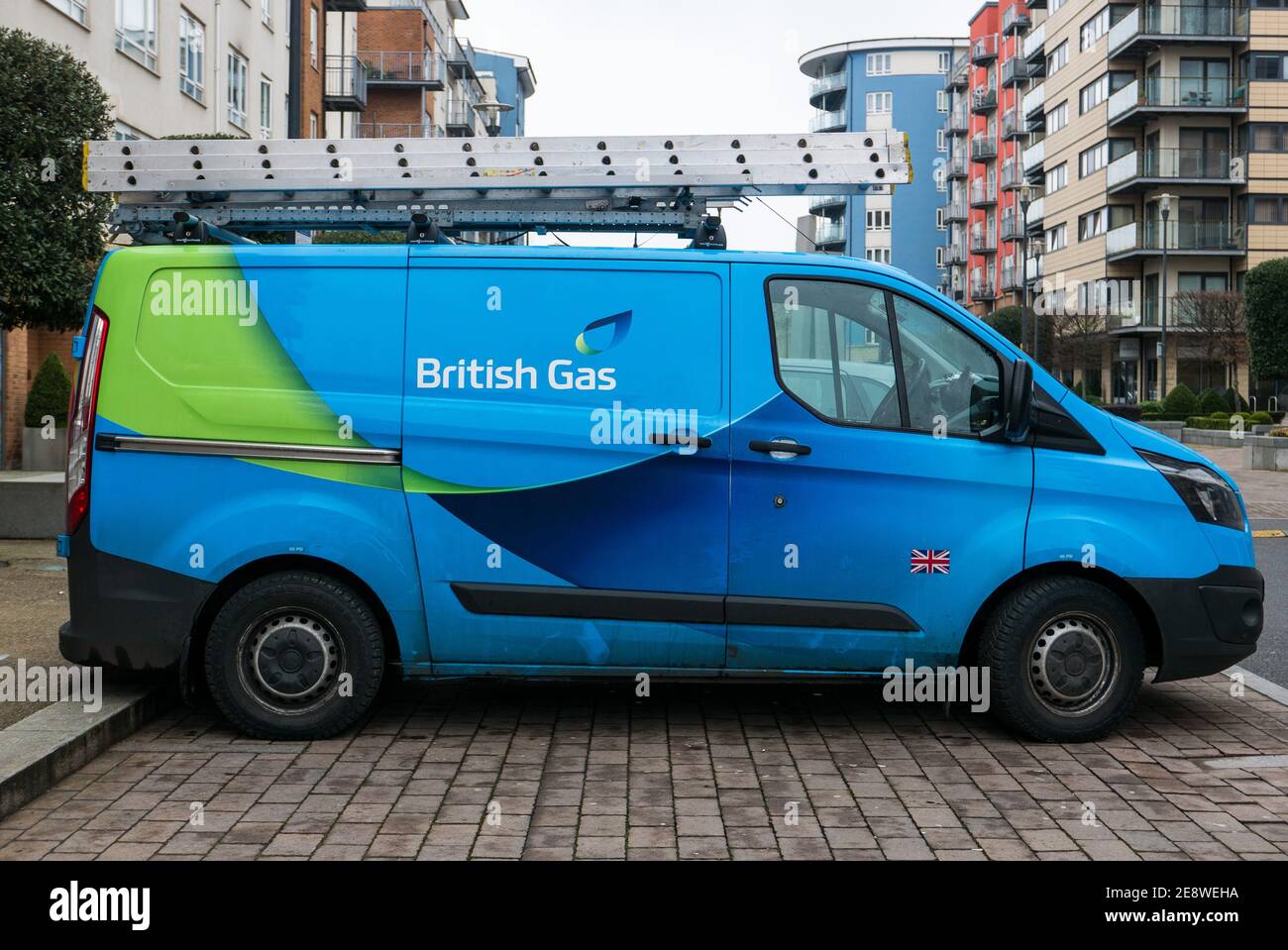 Blue British Gas (Ford Transit) van with a ladder on the roof parked in a residential area. Centrica owned British Gas. Stock Photo