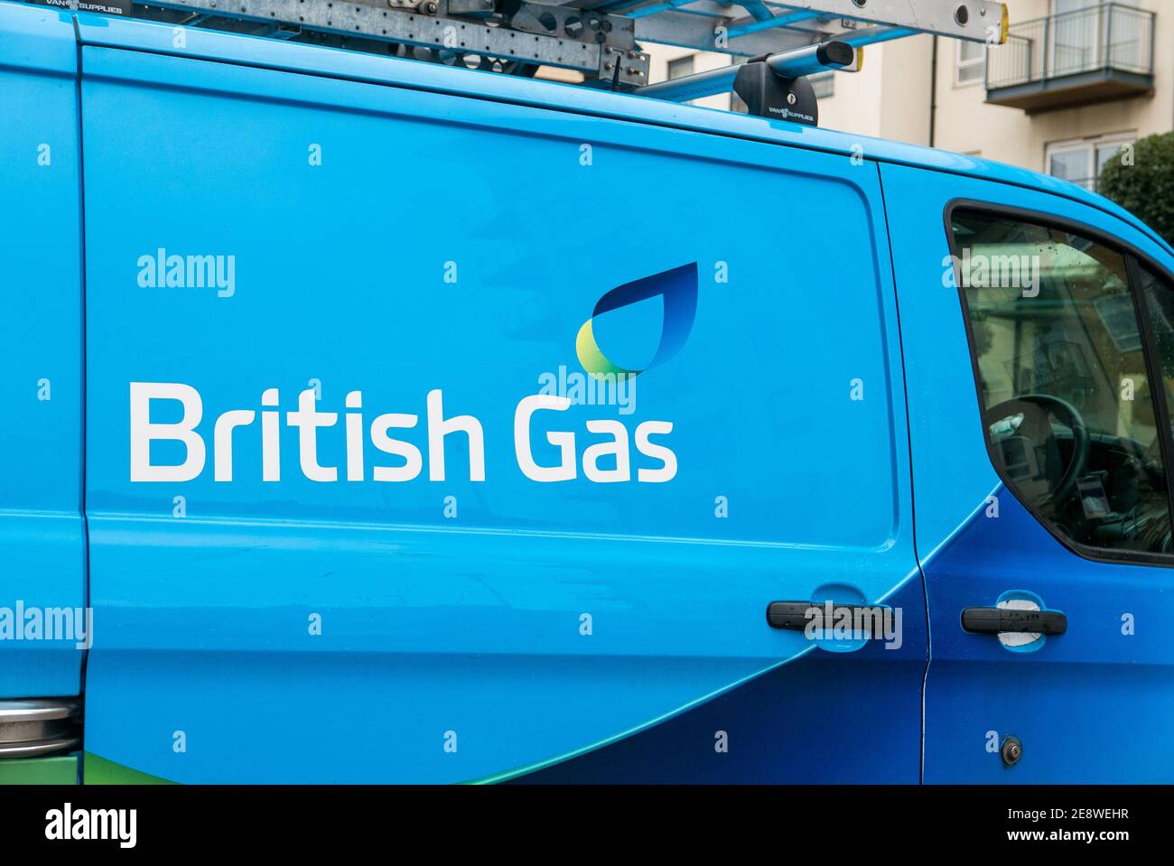 Blue British Gas (Ford Transit) van with a ladder on the roof parked in