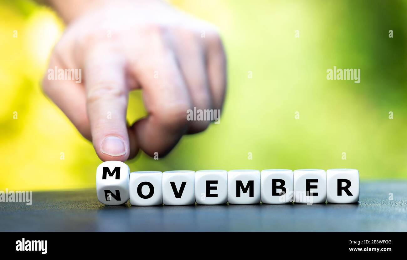Hand turns dice and changes the word November to Movember. Movember is an annual event to raise awareness of men's health issues. Stock Photo
