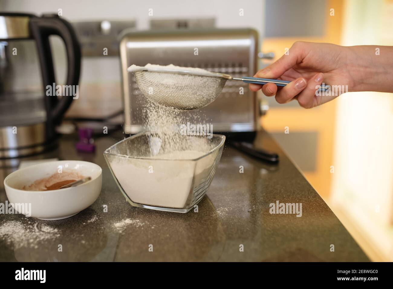hand holding a strainer and sifting flour Stock Photo Alamy