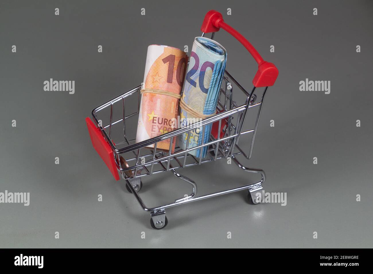 Small shopping cart with banknotes of ten and twenty euros Stock Photo