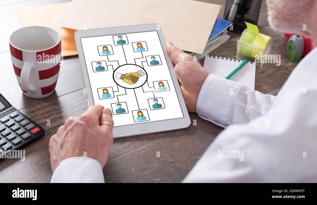 Collaboration concept shown on a tablet held by a man Stock Photo
