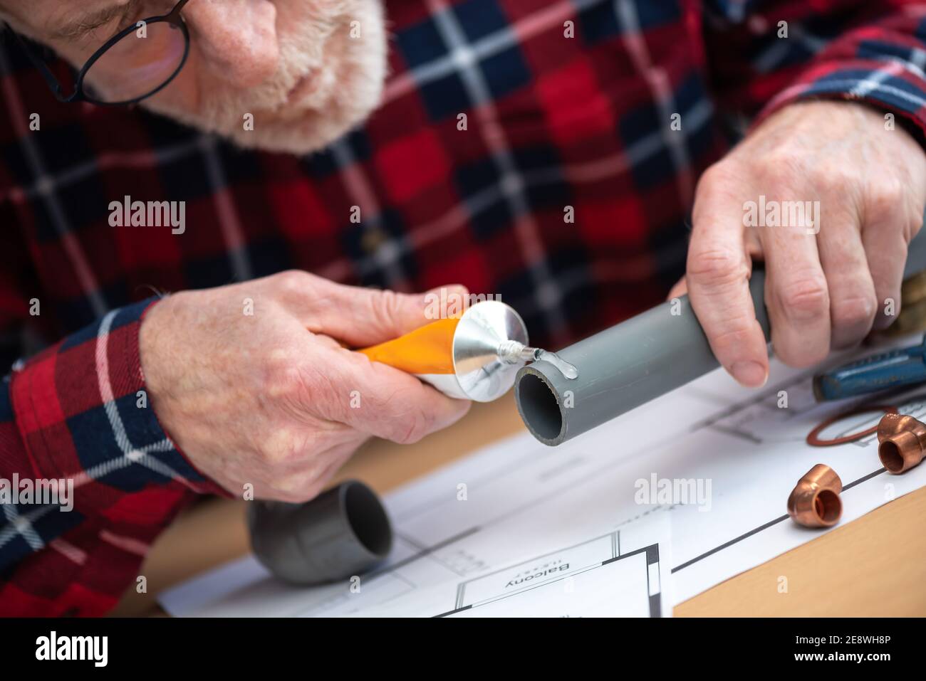 Plumber putting glue on a pvc pipe Stock Photo Alamy