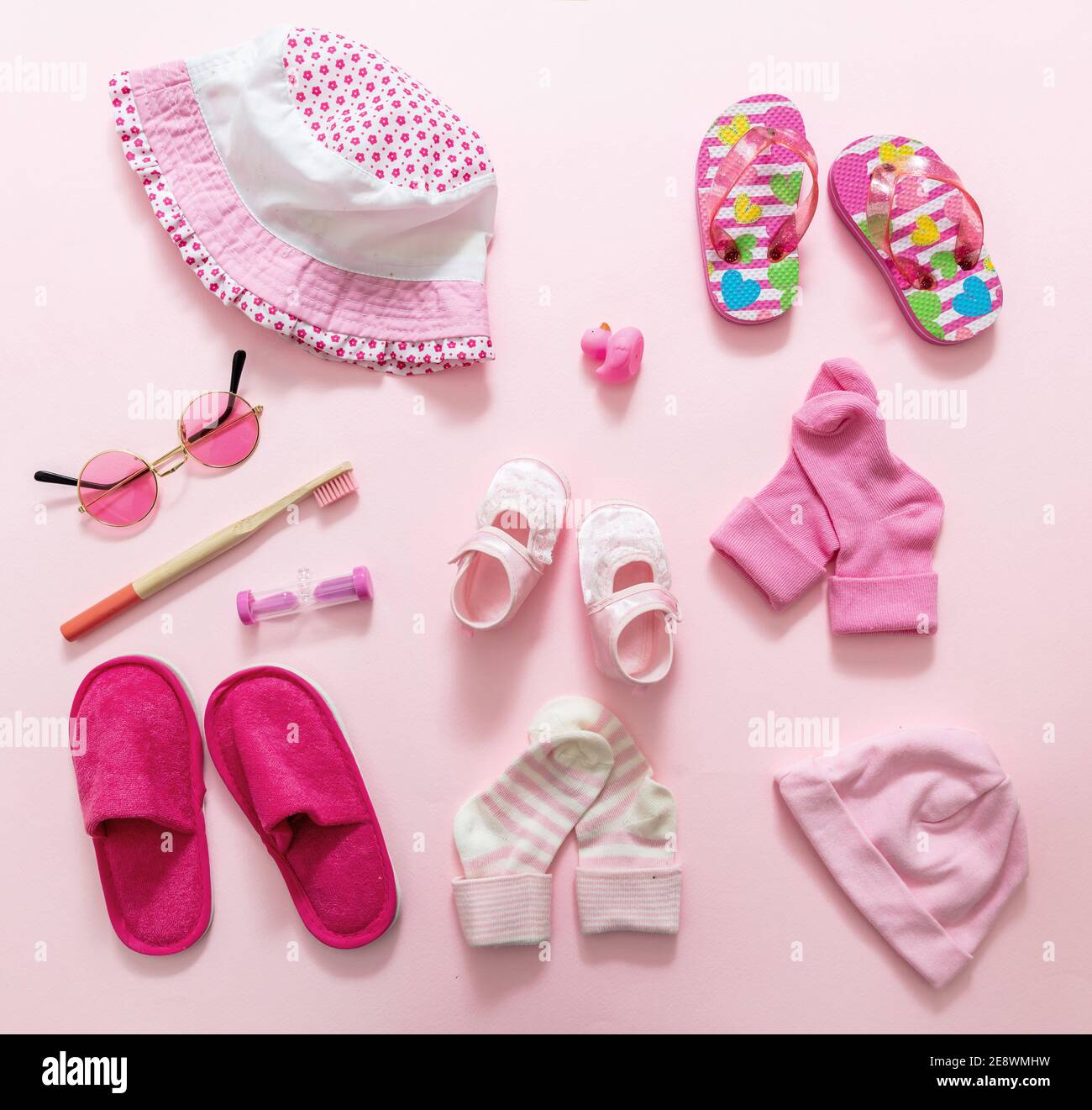 Baby girl accesories, baby shower flat lay. Pink color clothes and supplies for newborn child on pink background, top view Stock Photo