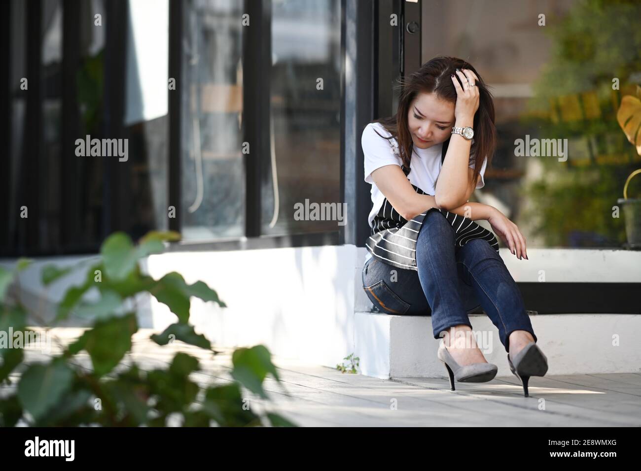 Asian woman coffee shop entrepreneur stressed because of economic conditions. Stock Photo