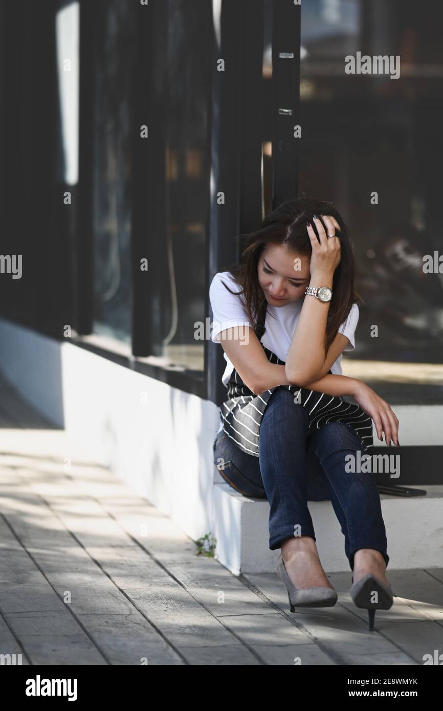 Portrait of Asian woman coffee shop entrepreneur stressed because of economic conditions and business losses. Stock Photo