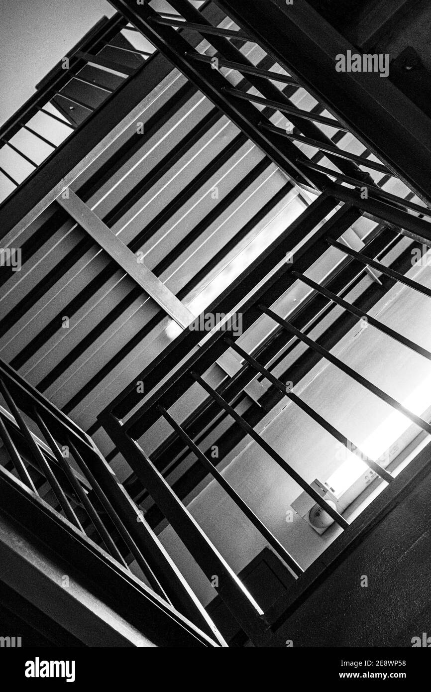 The lines of steps and railings in a stairwell create an abstract ...