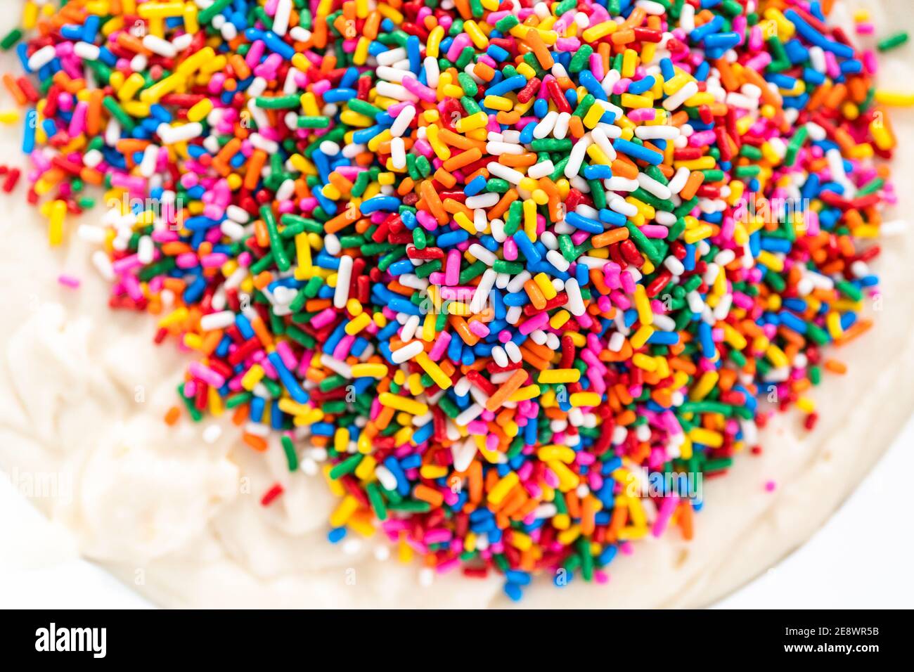 Mixing ingredients to bake birthday funfetti cake with colorful