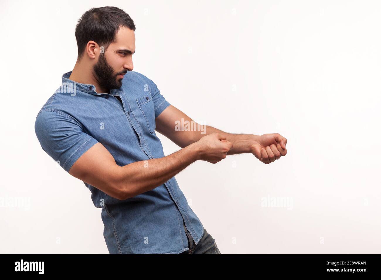 Profile portrait strong assertive man purposeful businessman with beard pulling invisible rope, showing his persistence and leadership qualities. Indo Stock Photo
