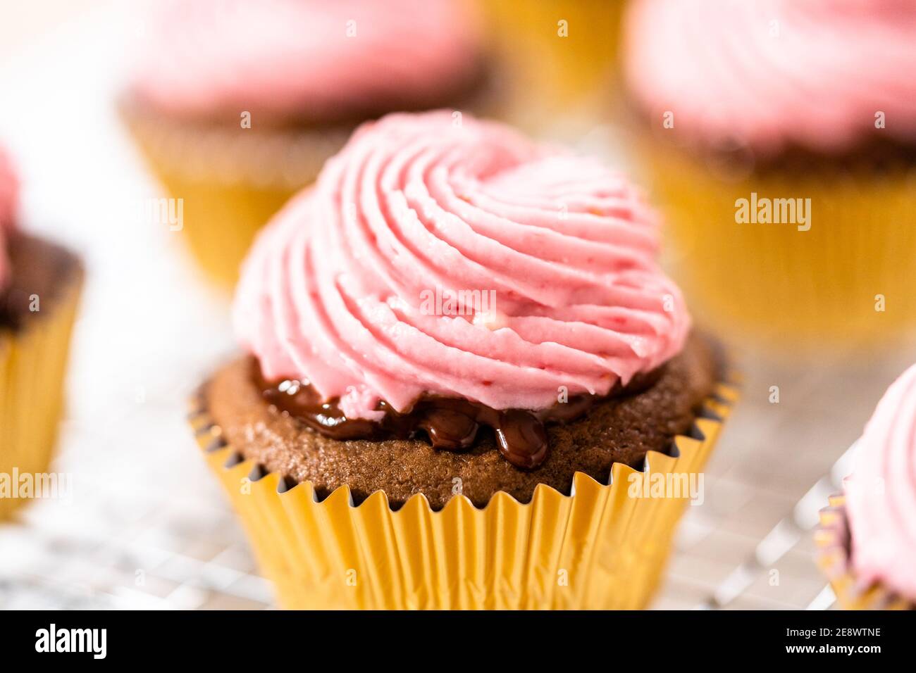 Frosting chocolate cupcakes with raspberry cream cheese buttercream Stock Photo Alamy